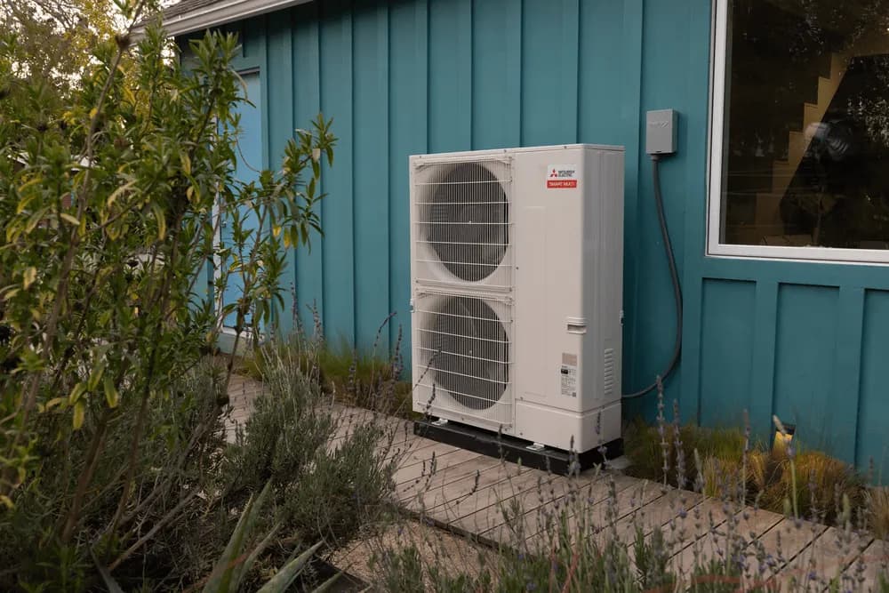 Outdoor air conditioning condenser unit beside a home